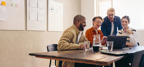 Cheerful business colleagues watching a presentation on a laptop