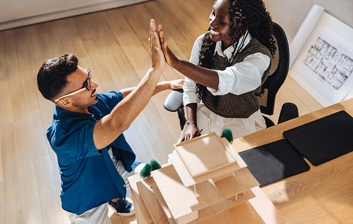 Team of young architects celebrating success at their studio workspace