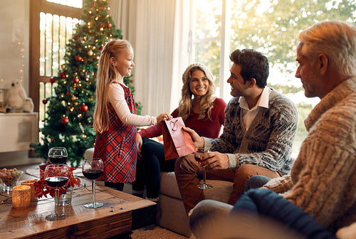Cute little girl giving Christmas gift to her father