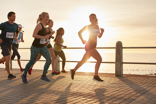 Fit young people running on the promenade by the sea