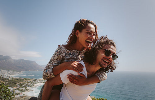 Smiling man piggybacking his girlfriend