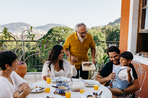 Family enjoying a Brazilian churrasco gathering on a sunny outdoor patio