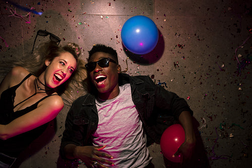 Couple lying down laughing at a party