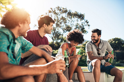 Friends partying in backyard garden with beers