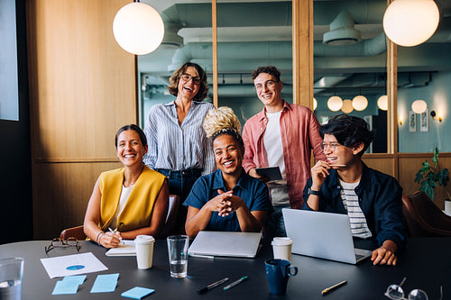 Group of young professionals laughing together at a meeting in an office