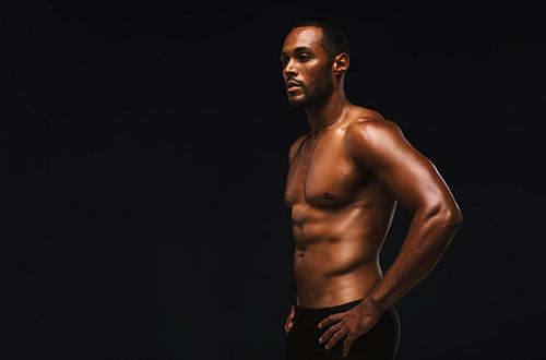Fit muscular man against black background