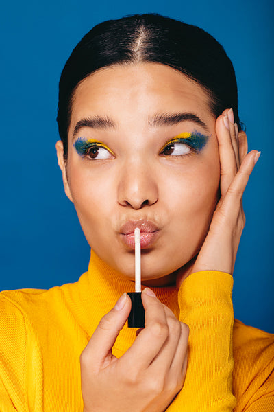 Feeling gorgeous, woman applies makeup on her face