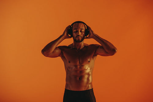 Portrait of muscular athlete enjoying music