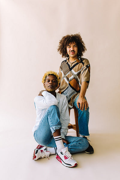 Young queer couple posing in a studio