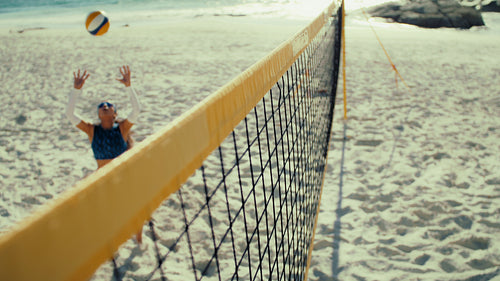 Overhead shot of professional female beach volleyball team spiking the ball