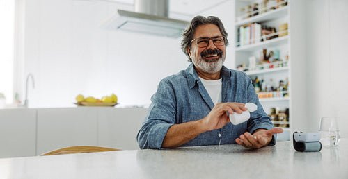 Medication user takes prescription pills with water at home