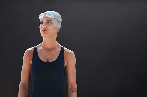 Fit young female swimmer looking away