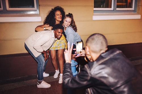 Young friends posing for a photo at night