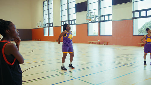 Young women practice basketball drills