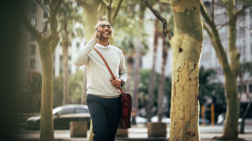 Businessman talking over mobile phone while commuting to office