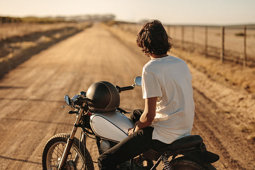 Man sitting on his vintage bike in countryside