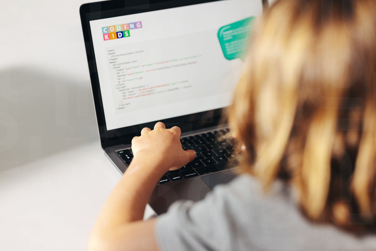 Young coding prodigy in action: Child programming on a laptop in a cla ...