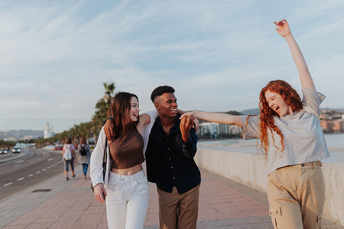 Vibrant young woman dancing while walking with her friends