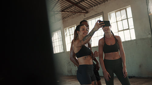 Group of friends taking selfie in gym