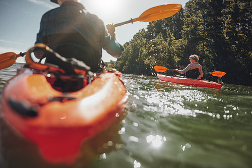 Mature woman kayaking in lake on a sunny day
