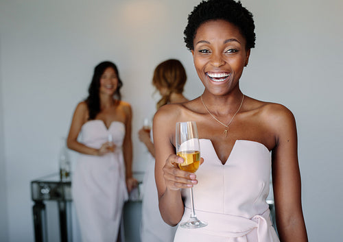 Beautiful bridesmaid having wine on wedding day