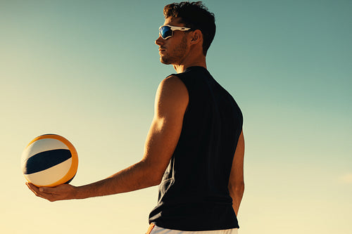 Young athlete playing beach volleyball championship on coastal beach