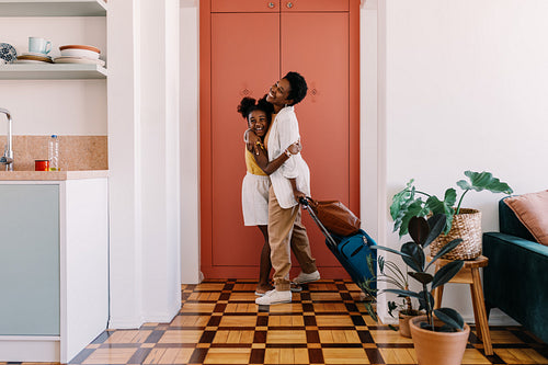 Excited daughter welcoming her mom at the door, hugging her in a joyful reunion