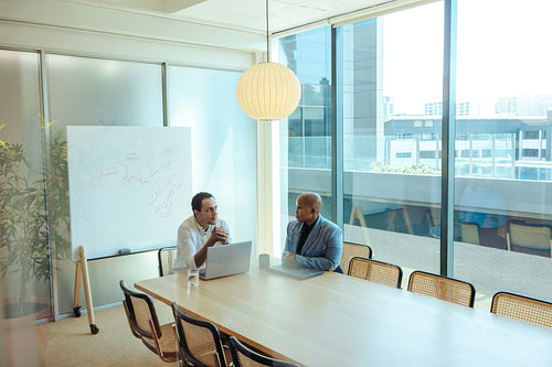 Discussion between two executive professionals in a modern office
