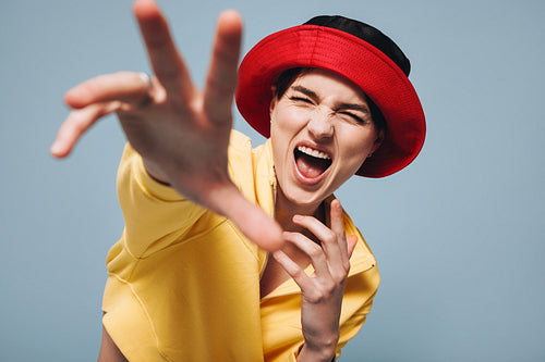 Energetic young woman cheering at the camera in a studio