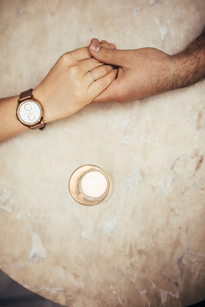 Close up of hands of a romantic couple on a table