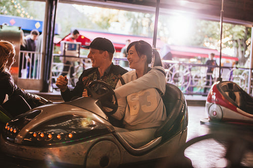 Friends on bumper car ride in amusement park