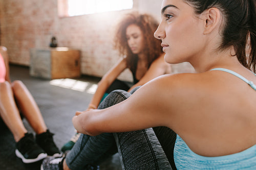 Young woman sitting with friends in gym