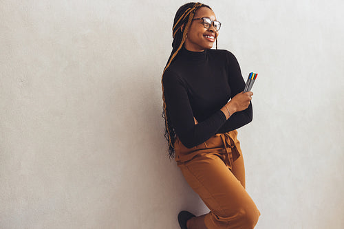 Smiling graphic designer holding coloured pens