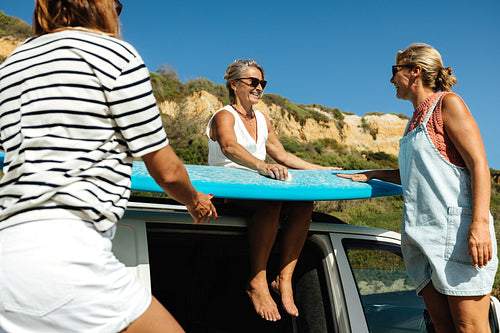 Group of mature friends enjoying a sunny day with a surfing adventure