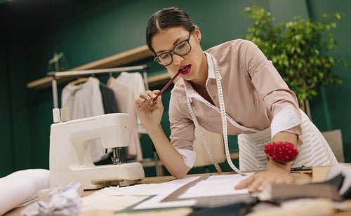 Female tailor thinking over new dress design
