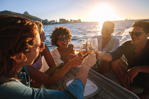 Cheerful friends drinking together on yacht