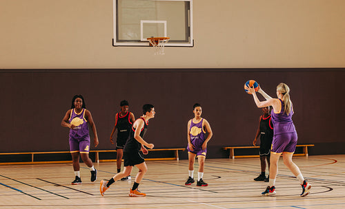 Focused on the goal: Female basketball player takes aim for a three-pointer