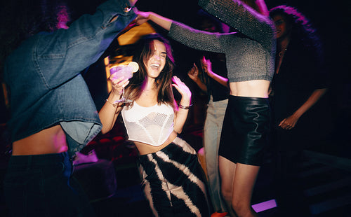 Friends having fun and dancing at a club with vibrant nightlife vibes
