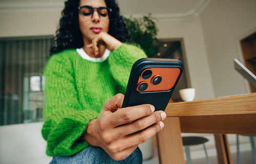 Woman uses smartphone for communication at a table in office setting