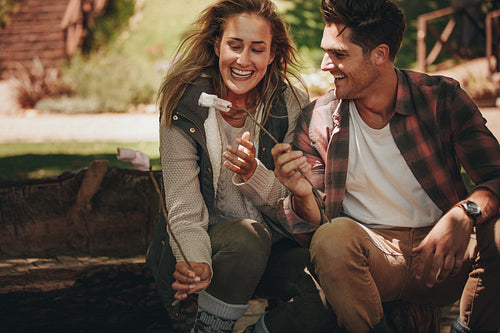 Camping couple having roasted sweets