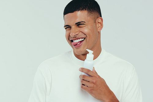 Fun skincare routine: Man enjoys using face product in grooming routine