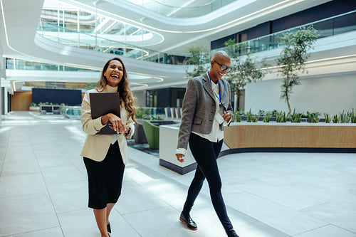 Indian and African professionals walking in modern office