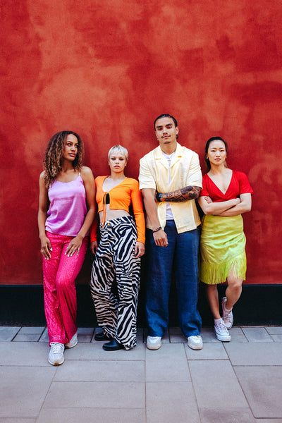 Diverse group of friends pose together in an urban street with colorful fashion and youthful group energy