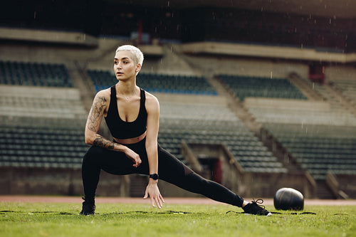 Fitness woman doing warm up exercises stretching her legs