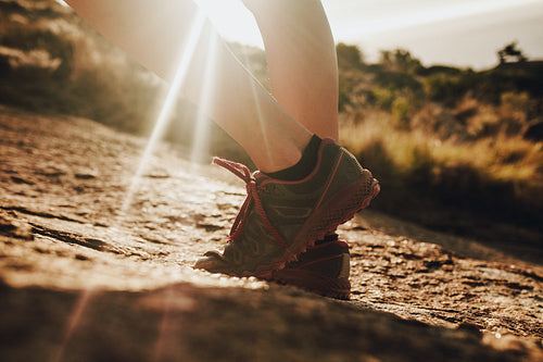 Female trail runner standing in sunlight