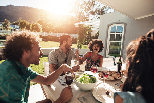 Friends hanging out with food and drinks outside the house