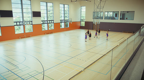 Youth practicing basketball in a gym