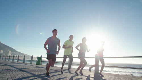 Running club group running along a seaside promenade