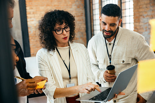 Professional team discussion during a business meeting with a focus on a laptop