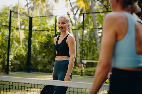 Blonde woman playing padel at a tropical resort